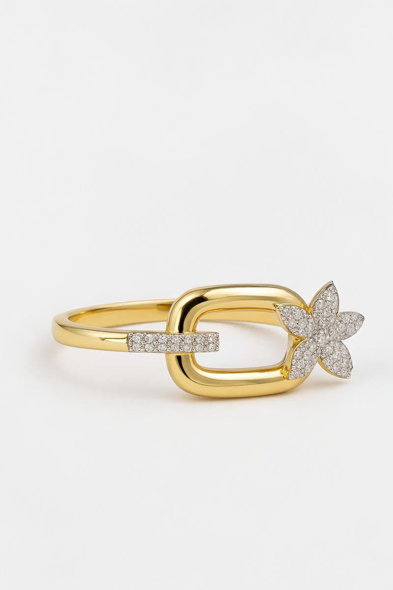 Gold ring with a floral shaped diamond design on a light gray background