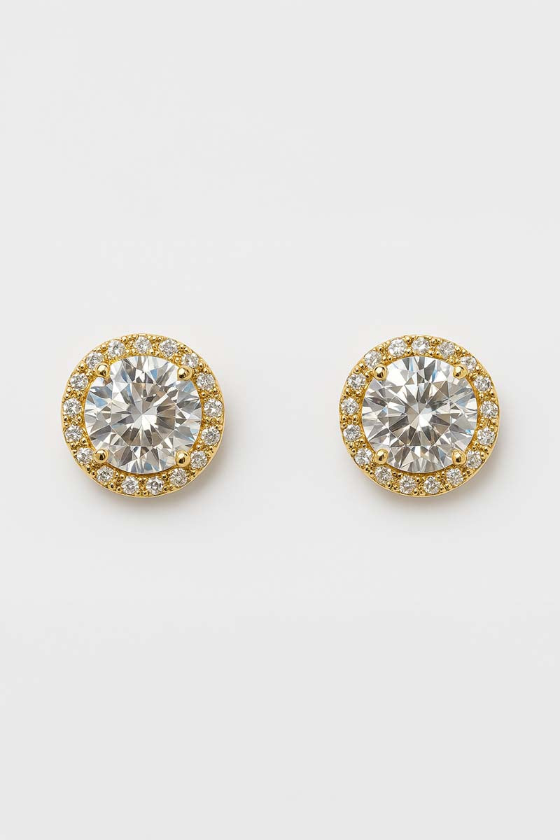 A pair of gold stud earrings with a central clear crystal surrounded by a smaller halo of clear crystals.