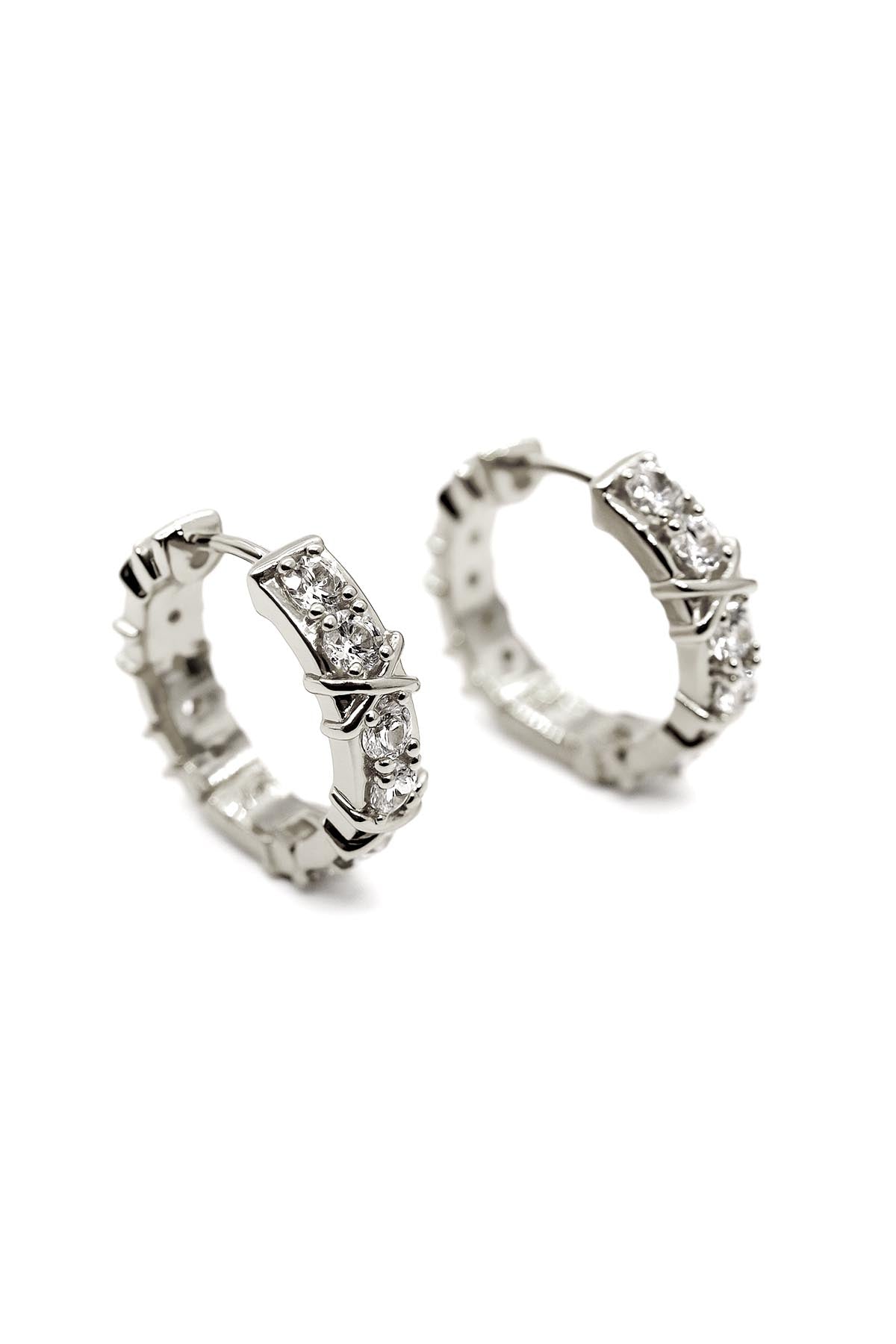 Silver hoop earrings with gemstones on a white background