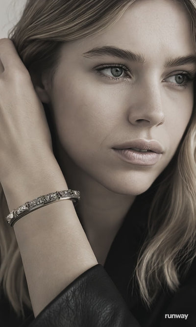 Video of a beautiful thirty-year-old blonde woman showcasing a silver bangle on her wrist.